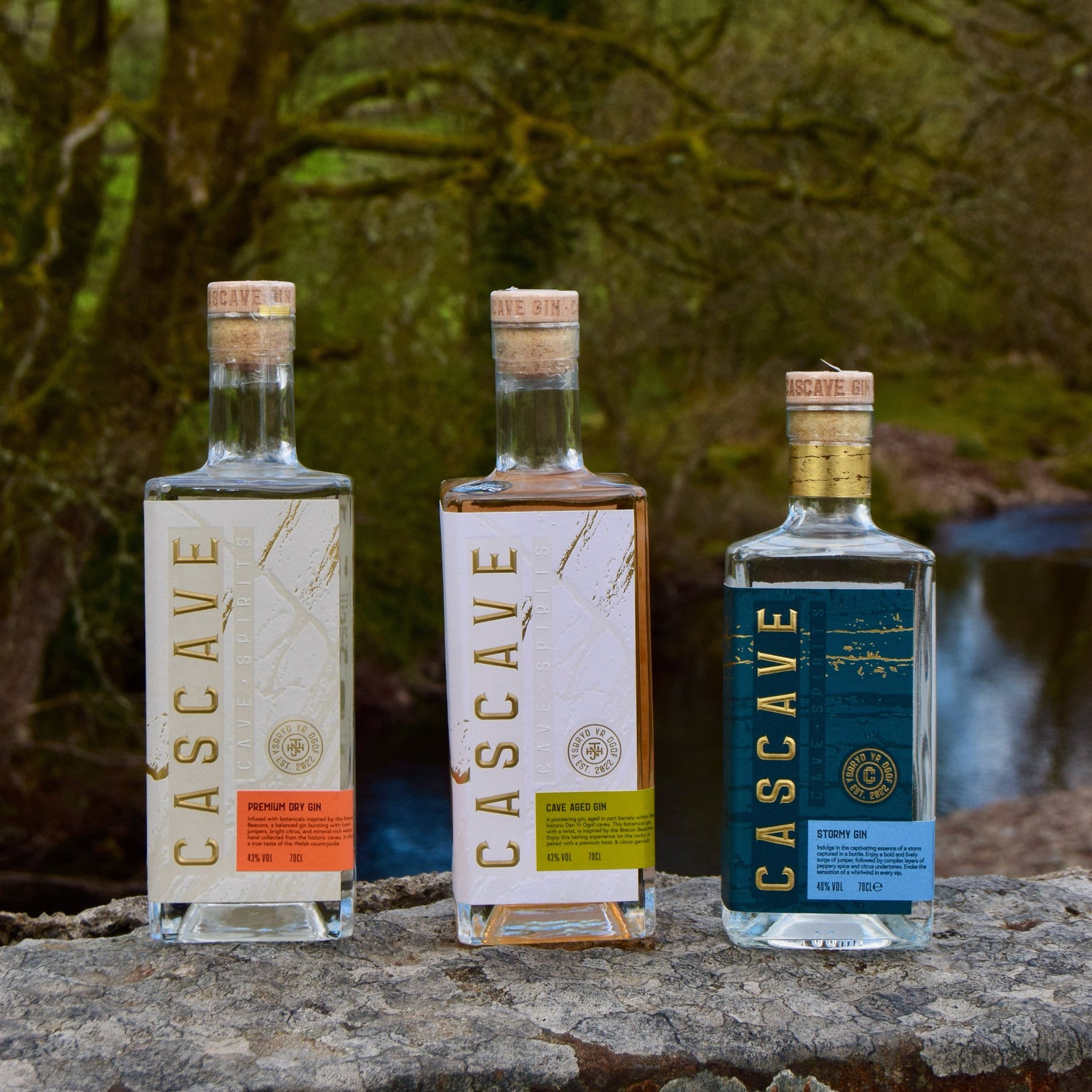 Three bottles of Cascave gin on a stone surface with a natural background