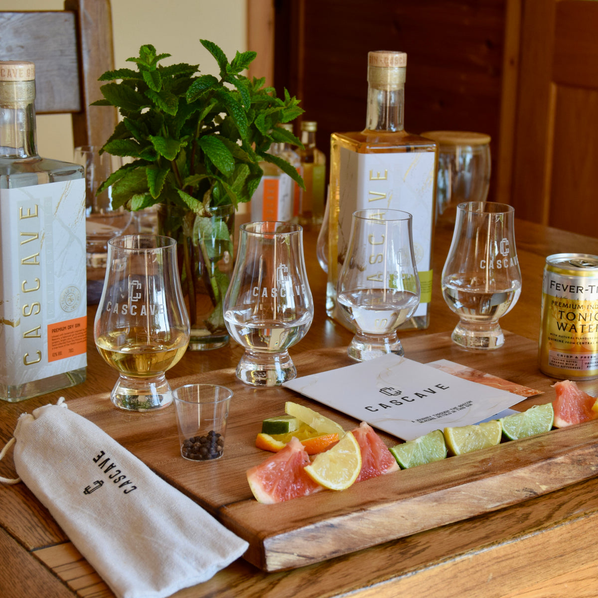 Welsh Gin tasting setup with glasses, bottles, and garnishes on a wooden table in Wales. Amazing gift. 